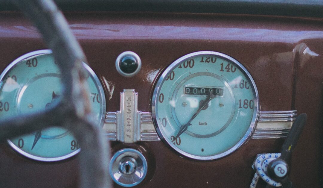 The dashboard of an old-timey truck shows an odometer and speedometer.