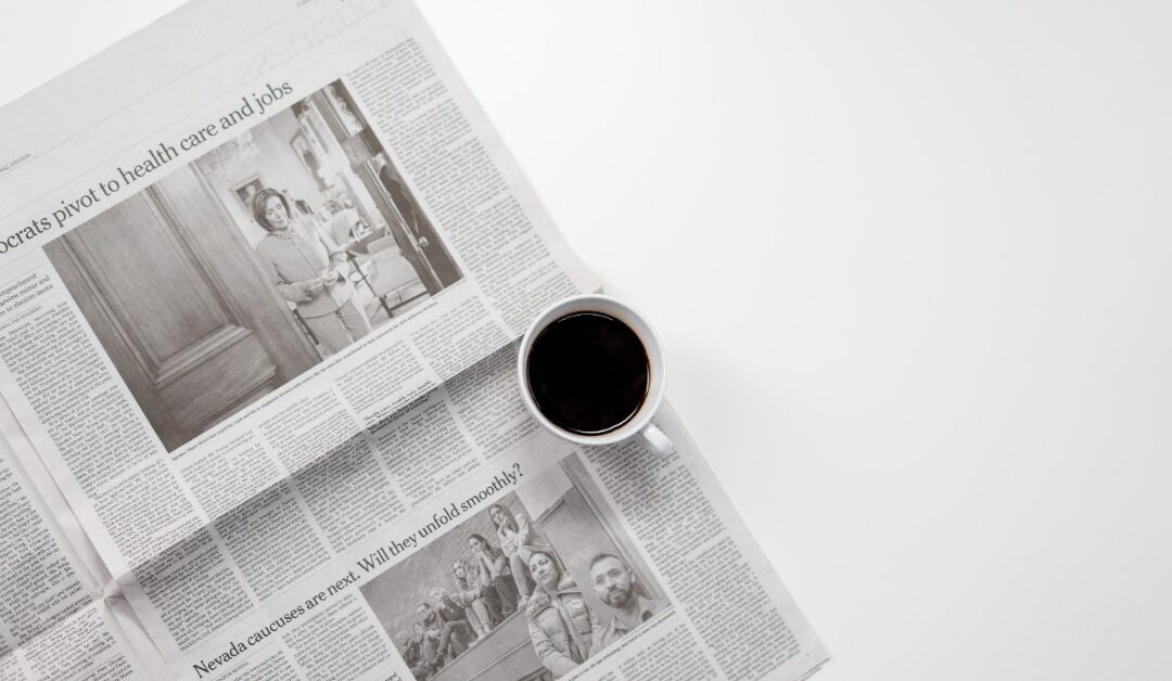 A cup of coffee sits on an open newspaper with headlines of political intrigue.